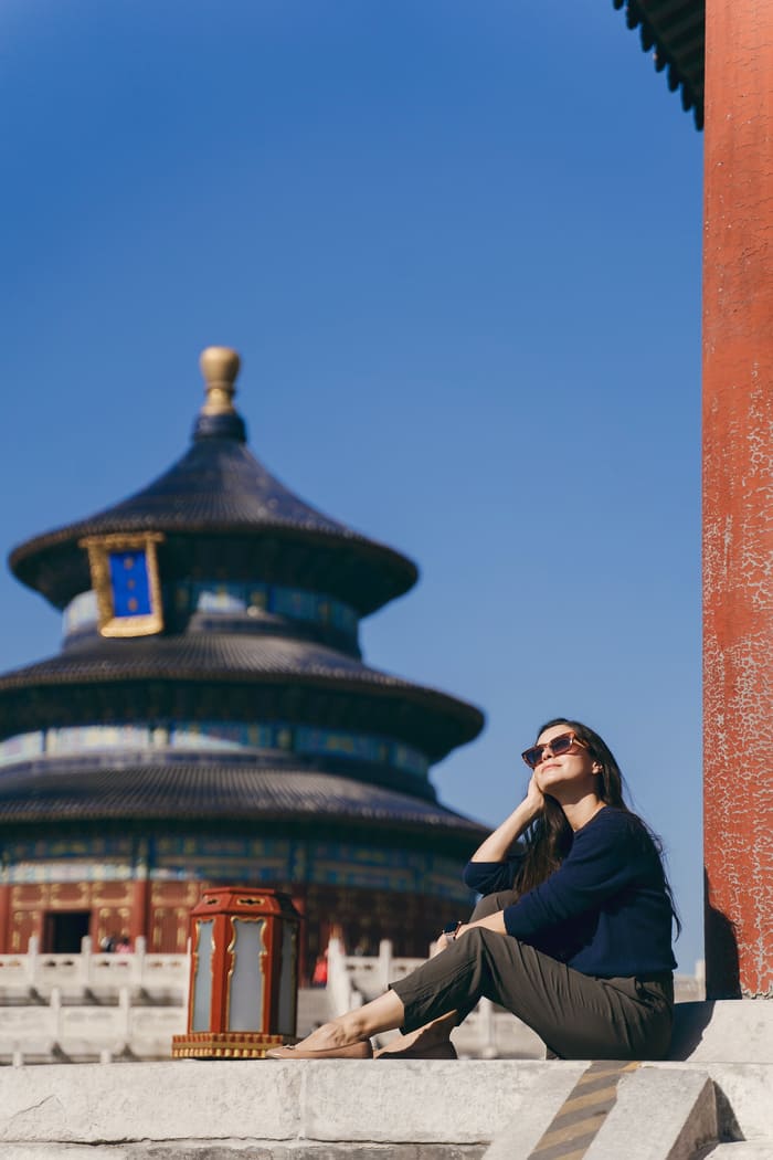 Edificio del Templo del Cielo en Beijin con una mujer que posa frente al templo