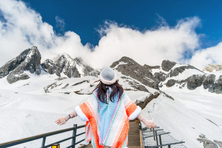Mujer en una caminata en las montañas cubiertas de nieve de Yangsho
