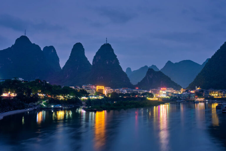 Poblado de Yangshuo de noche. Vista de montañas, cuidad y lago.