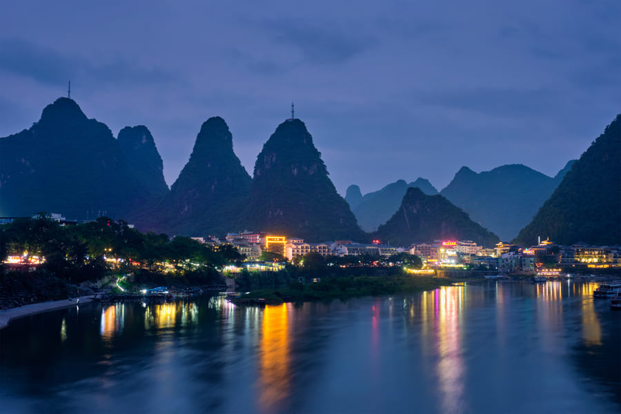 Poblado de Yangshuo de noche. Vista de montañas, cuidad y lago.